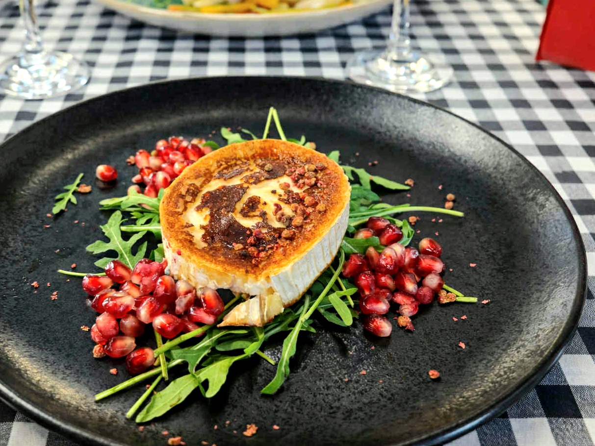 Mézes kecskesajt rukkola ágyon, rózsabors morzsával, gránátalmával